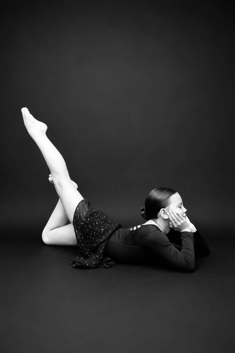 Belong dancer performing a floor pose in a black costume